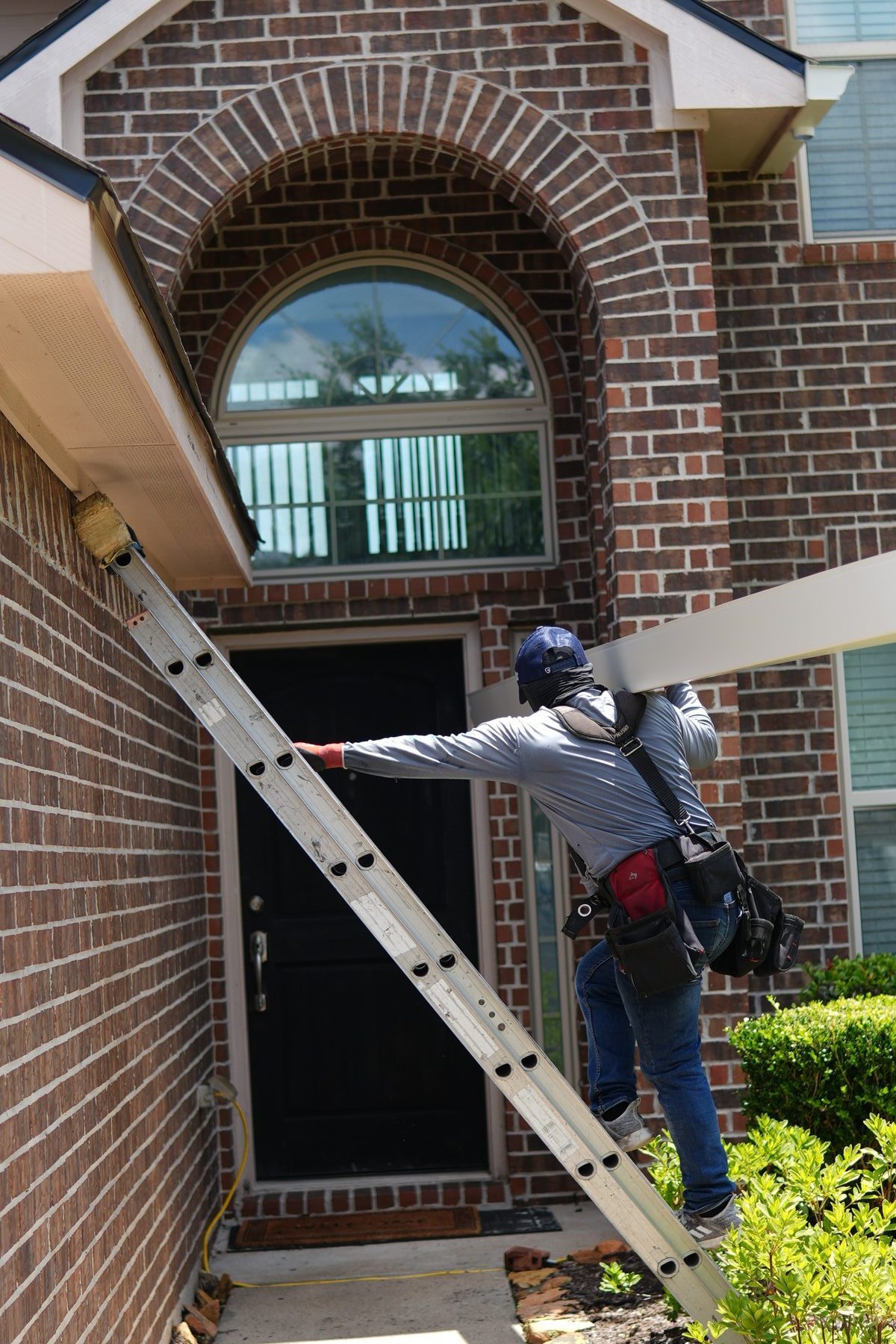One Sun America installer carrying seamless gutter up ladder for installation